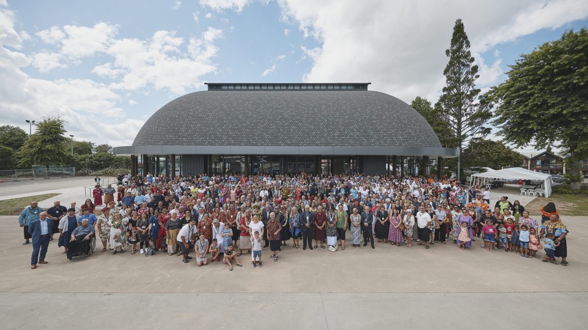 Giant group photo of everyone who attended the K'aute Pasifika Fale opening, standing in front of the fale.