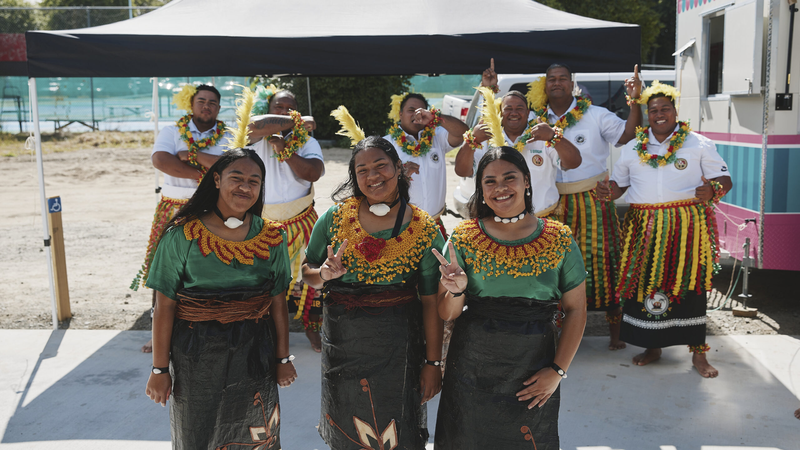 Pasifika performers smiling and posing in costume