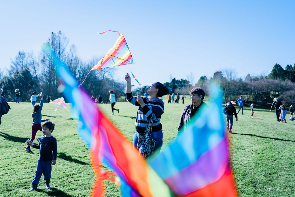 Family flying kites in the park at a Matariki ki Waikato event