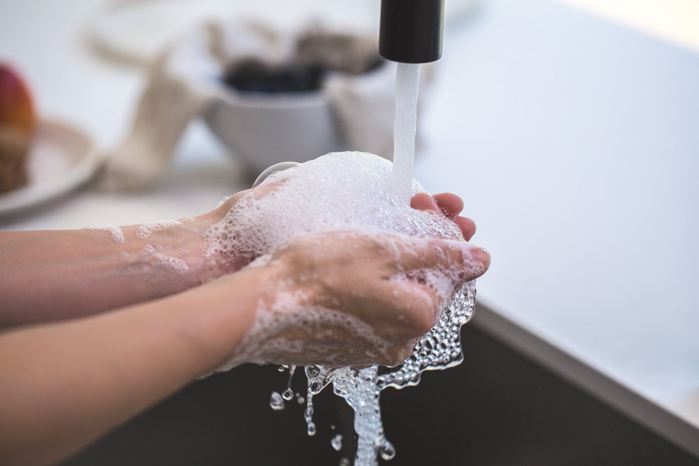 Hands being washed with soap suds.