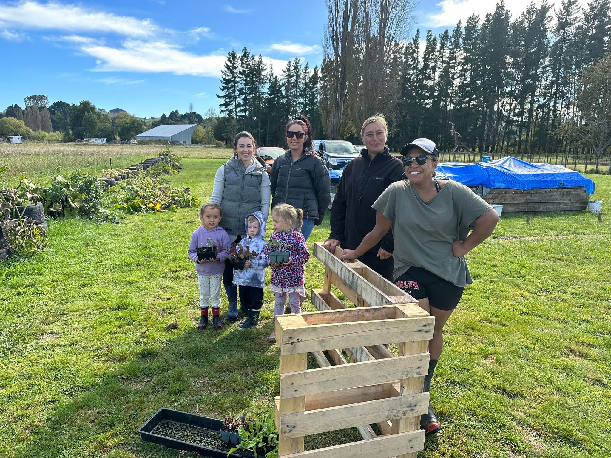 Three children and parents utilising the services of Taumarunui Whakaarotahi Trust at their community garden