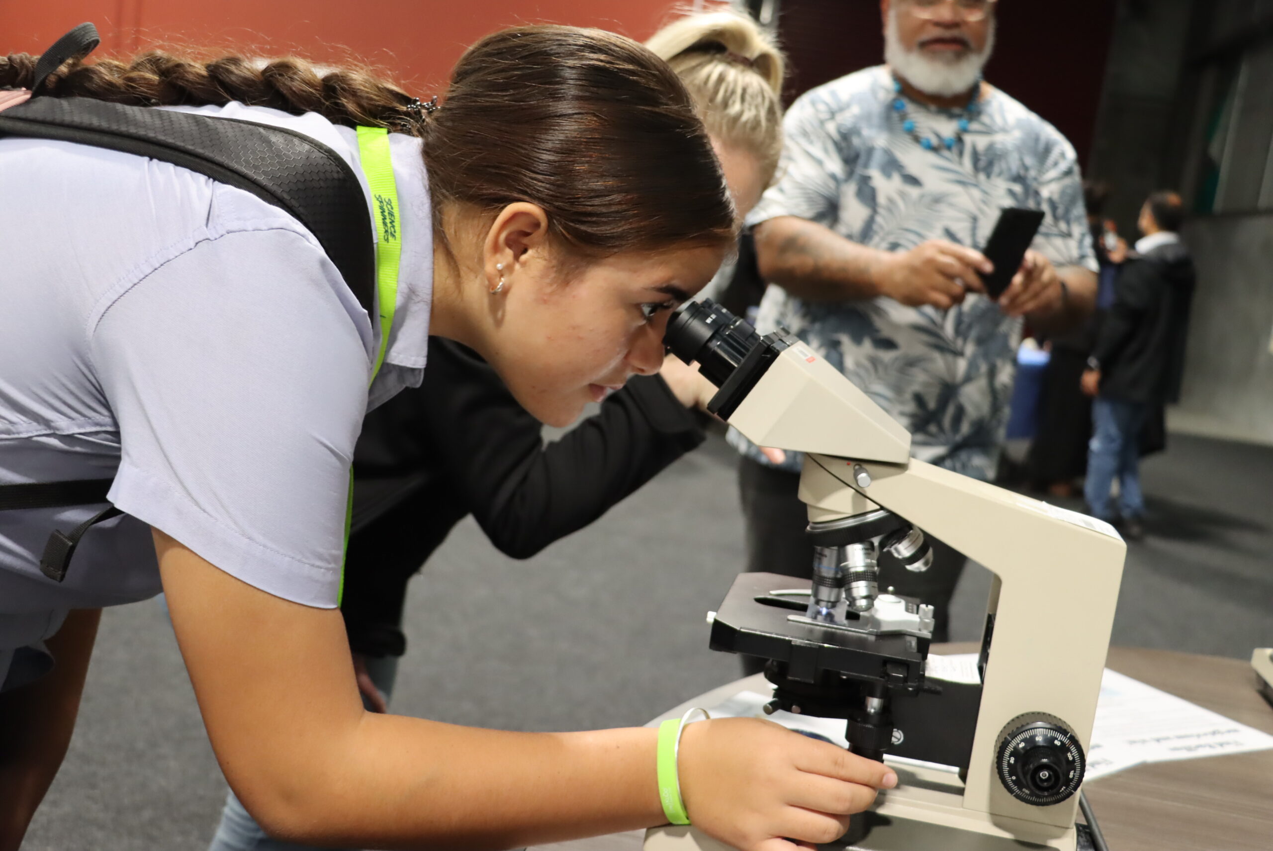Teenage girl looking through microscope